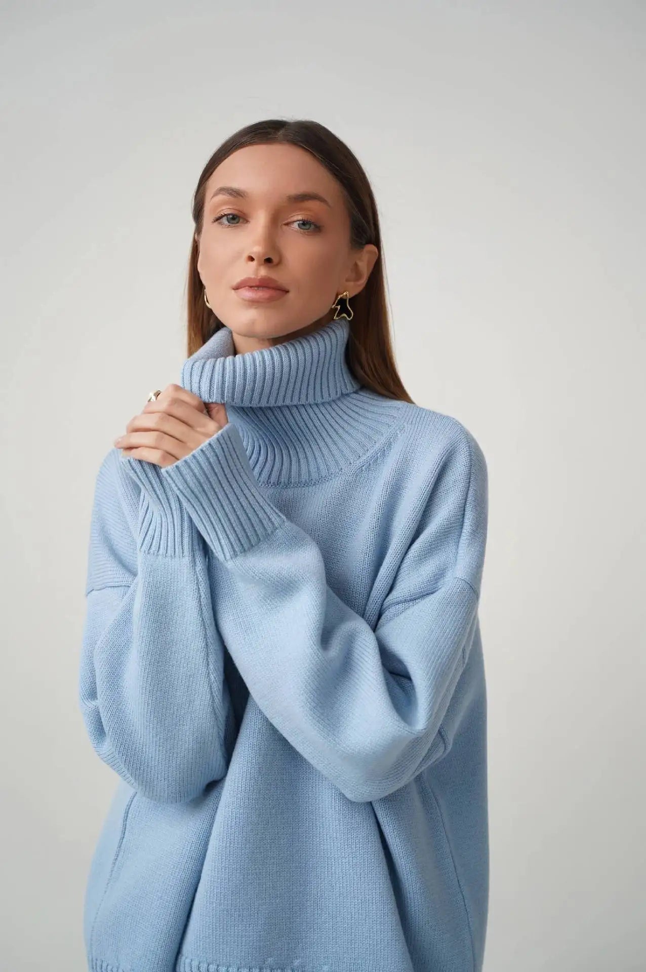 Woman wearing a light blue sweater against a plain background