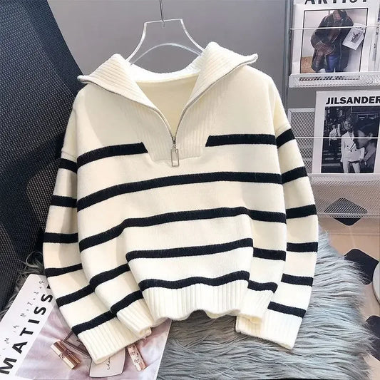 White and black striped sweater on a hanger with a magazine in the background